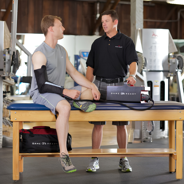 Athlete using a Game Ready GRPro 2.1 with an elbow wrap in a training room